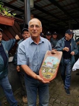 Vaški godbeniki so gospodu Knezu, ki z ženo skrbita za kapelico, izročili opeko s stare kapelice